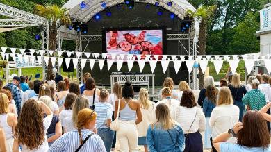 
		pme employees from the Hanover region are standing in front of an open-air stage
	