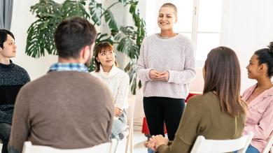 
		The speaker stands in front of a group of seminar participants
	