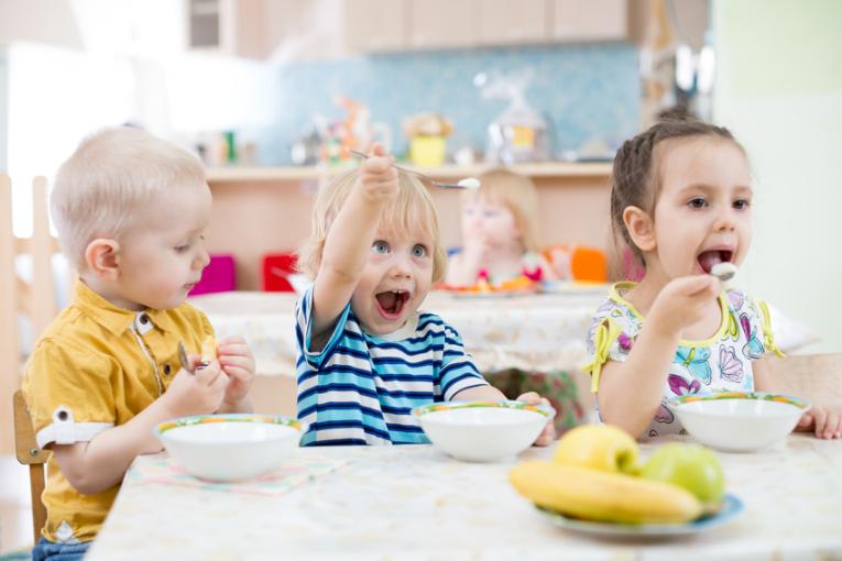 Children eat at the table in a childcare center