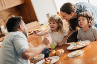 
		Parents with children at the lunch table at home
	