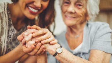 
		Older woman and young woman holding hands
	