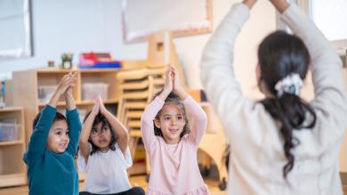 
		Teacher does yoga with children
	