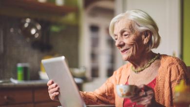 
		Old lady looks contentedly into a tablet
	