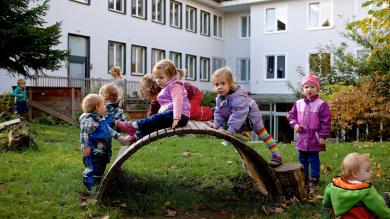 
		Children on a piece of play equipment in a learning world childcare center
	