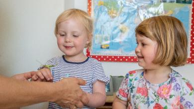 
		two little girls with a grasshopper on their hand
	