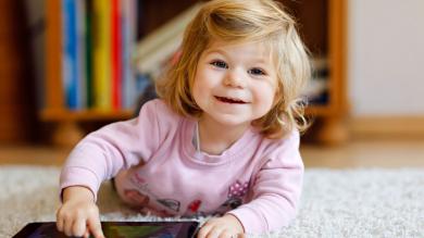 
		Little girl plays with tablet
	