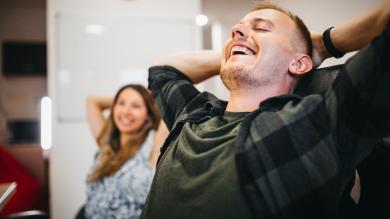 
		Mann und Frau im Büro lehnen sich entspannt zurück
	