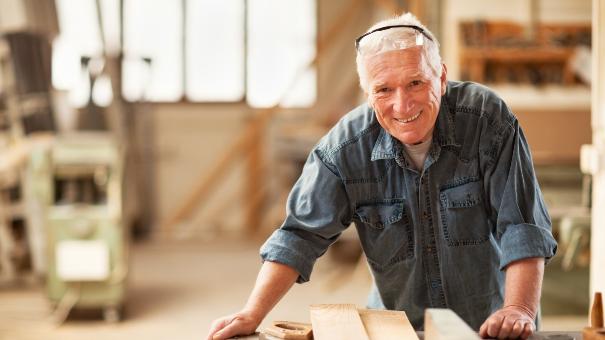 
		Elderly man standing at a workbench
	