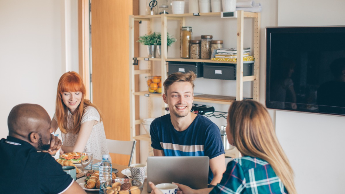 Young people sitting at the kitchen table in a shared flat