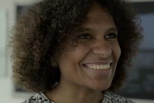 Young dark-skinned woman smiles cheerfully.