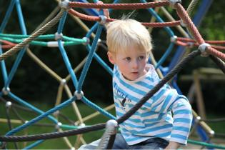 Boy playing in a climbing rope construction