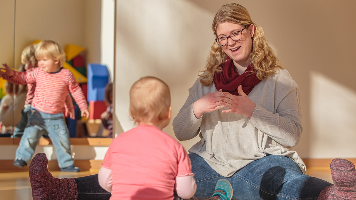 Educator with two children in the childcare center