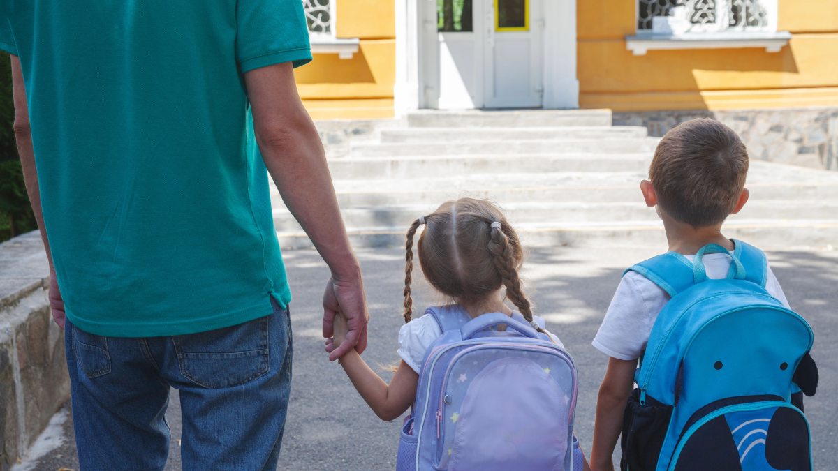 A father takes his children to preschool