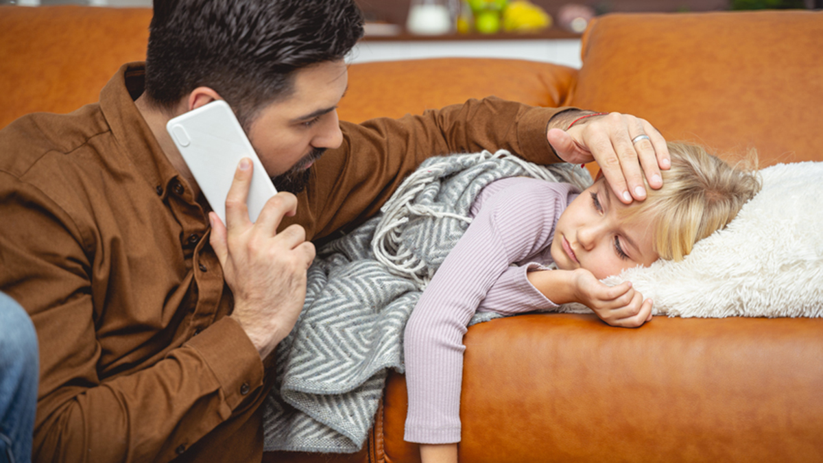 Father worries about sick child on the couch