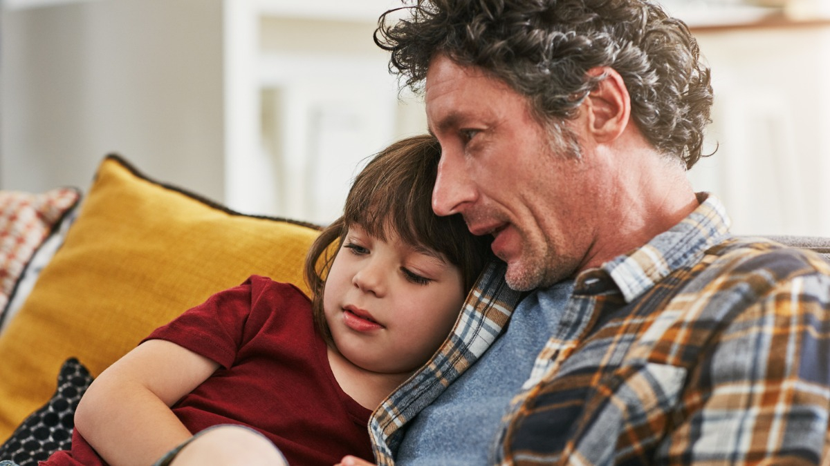 Kleines Kind mit Vater auf dem Sofa