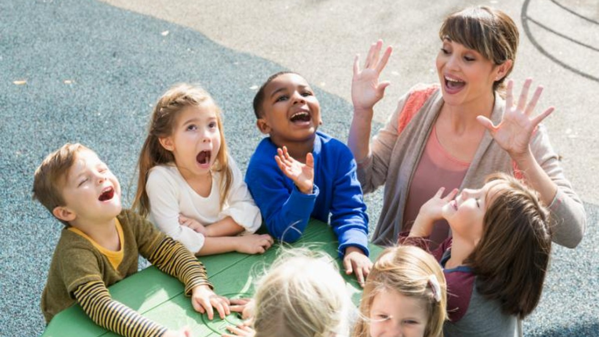 Teacher and children playing outdoors