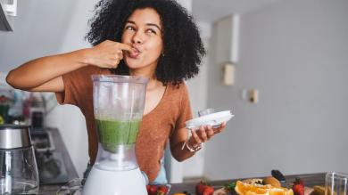 
		Young woman tries a smoothie from the blender
	