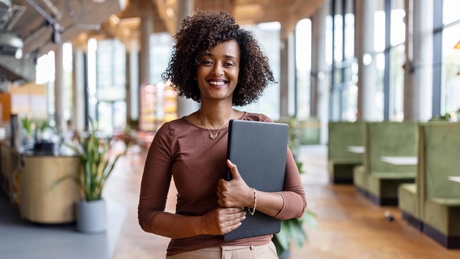 
		A woman in a leadership position is sitting at her desk with a laptop
	