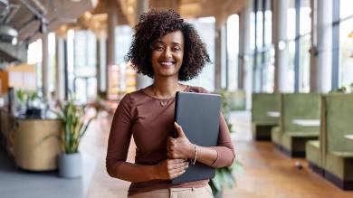 
		A woman in a leadership position is sitting at her desk with a laptop
	