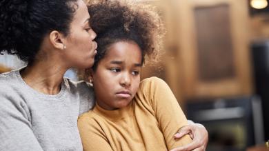 
		Mother comforts her sad daughter and gives her a kiss on the forehead
	