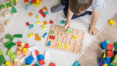 
		Child plays with colorful letters
	