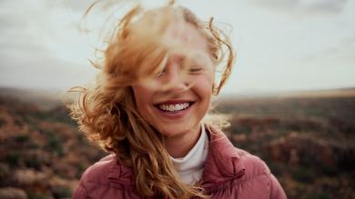 
		A young woman in a portrait smiles optimistically
	