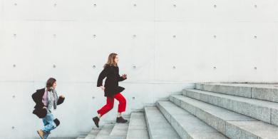 
		Two women run up the stairs one after the other
	