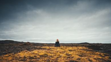 
		Man sits alone on a mountain
	