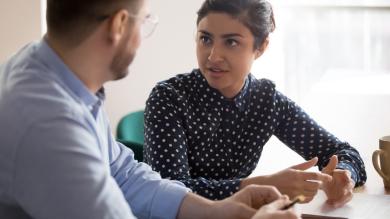 
		Young woman talks to young man in the office
	