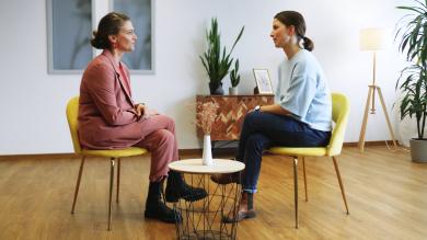 
		Two women sit opposite each other in coaching
	