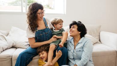 
		two women and two children sitting on a bed
	