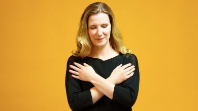 
		Woman concentrates and makes a butterfly hug
	