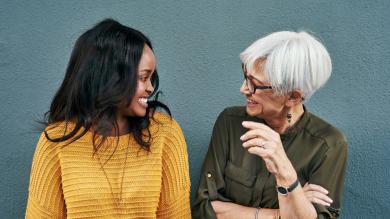 
		a young and an older woman smile at each other
	