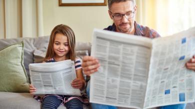 
		Father and daughter read the newspaper
	
