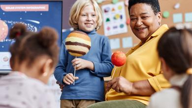 
		A child and a teacher are making models of planets
	