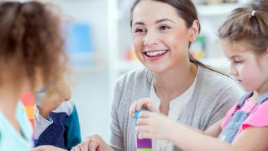 
		Childcare worker smiles at child
	