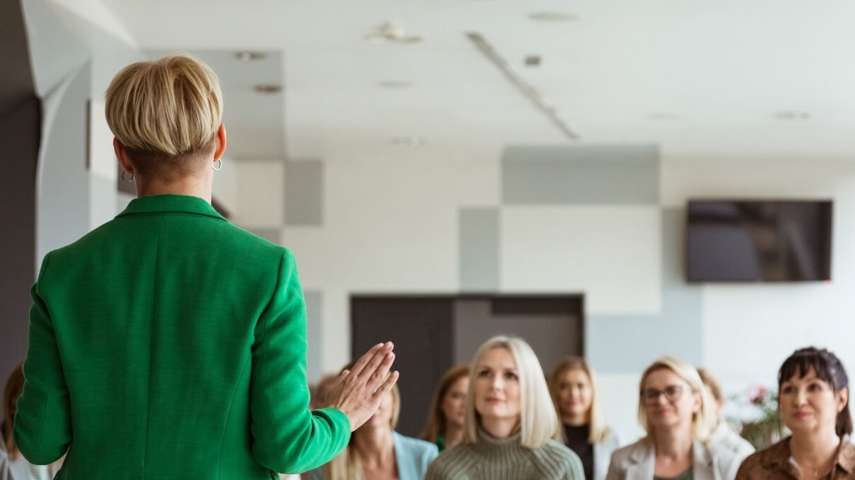 A woman speaking to a group of women