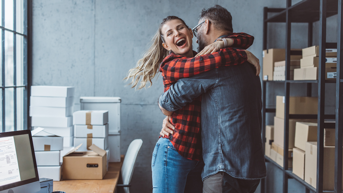 Woman hugs colleague at work