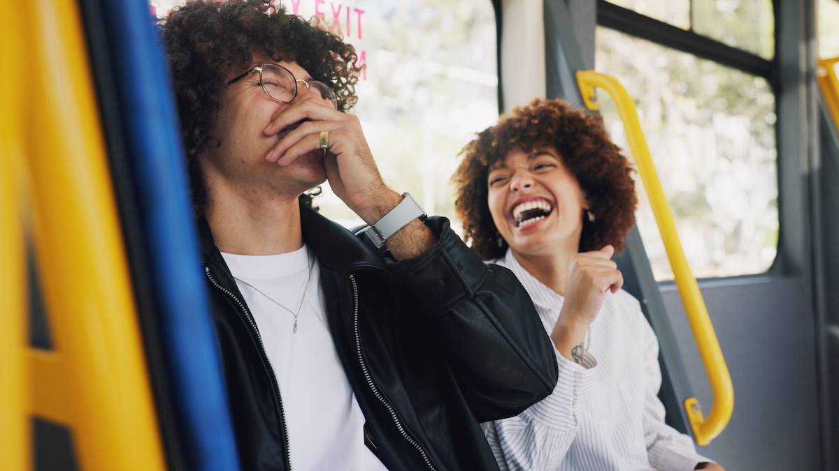 A couple is laughing on the subway and having a good time