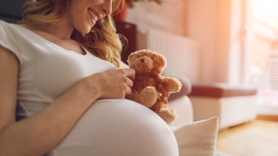A pregnant woman holding a teddy bear