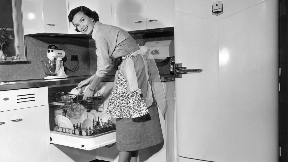 Photo of a woman from the 1950s putting away a dishwasher