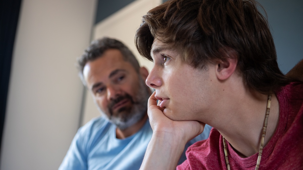 The father looks at his teenage son