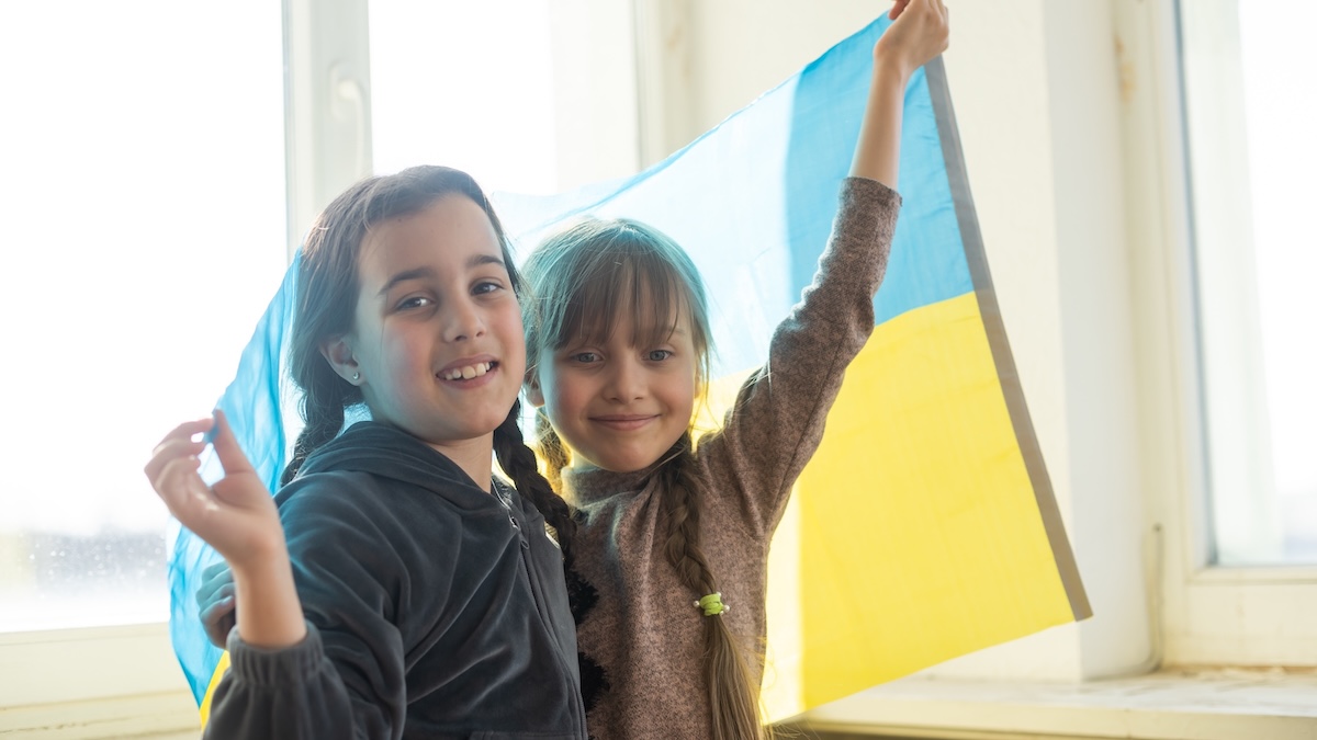 Two Ukrainian girls hold up a Ukrainian flag