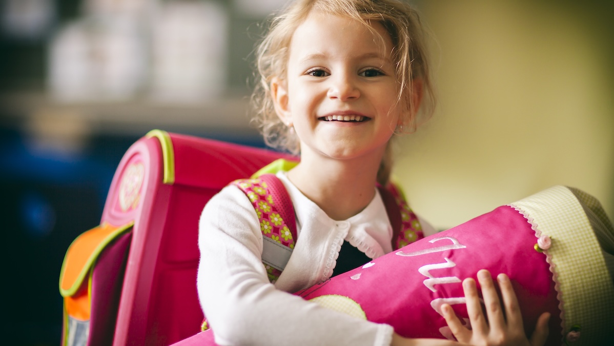A girl holds a school cone