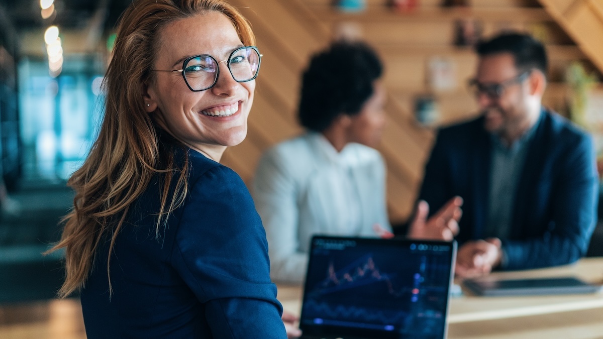 Woman calculating something at her desk with a laptop in the office