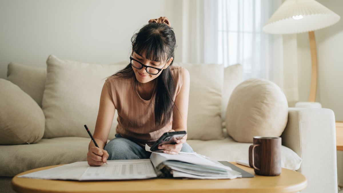 A woman sits at the table and does the math - parental allowance reform 2024