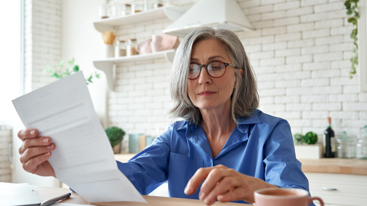 Female manager sits in home office with a wage garnishment in her hand