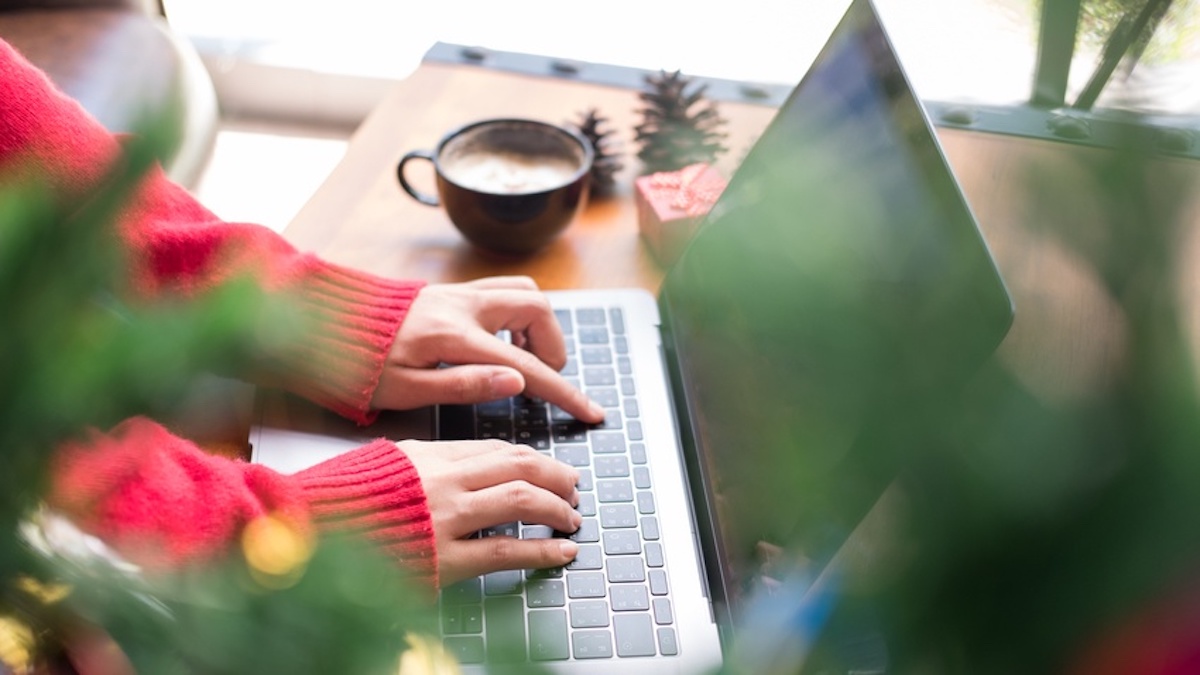 Close-up of female reading hands typing on a laptop keyboard