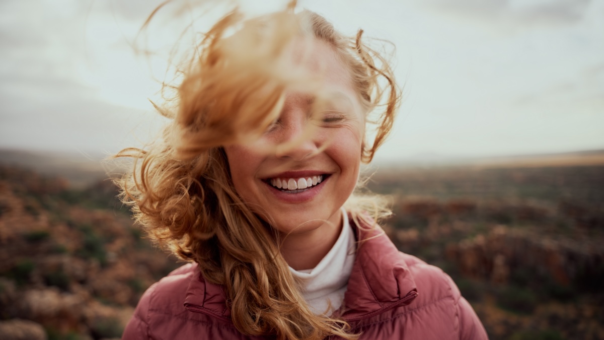 A young woman in a portrait smiles optimistically