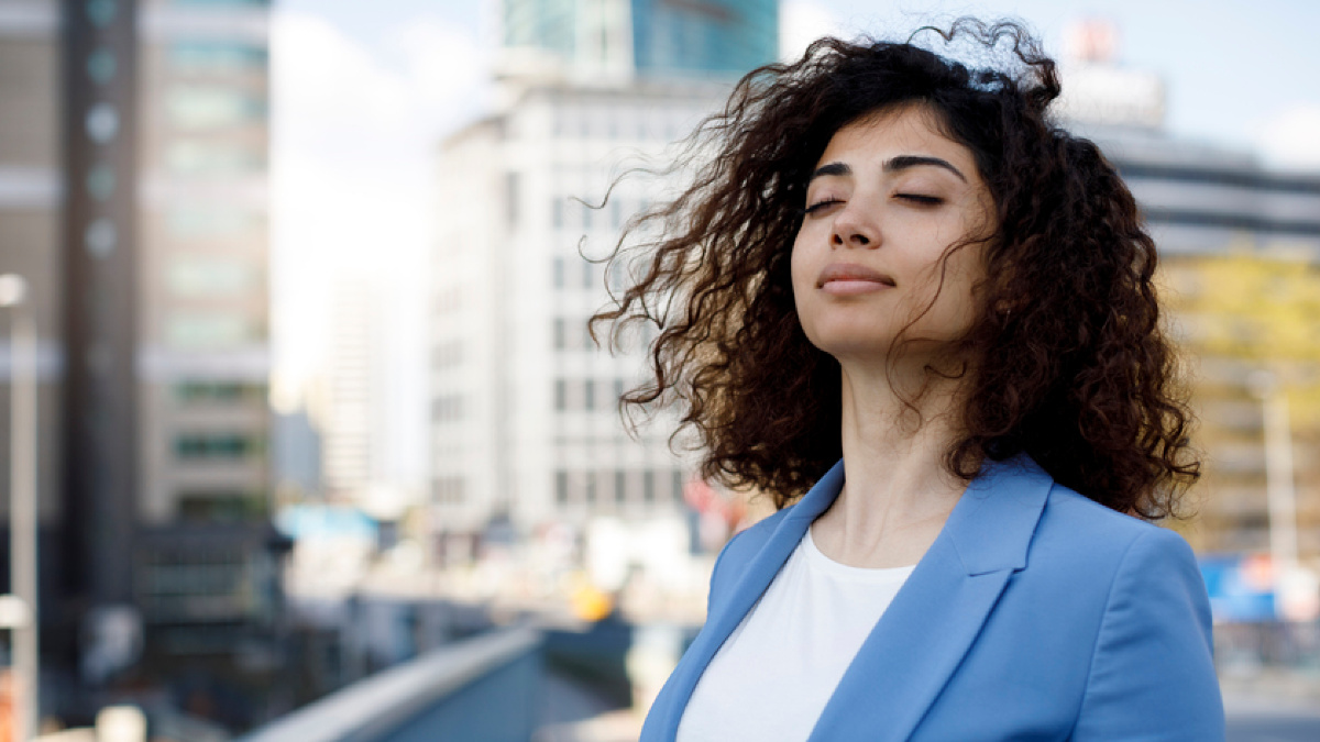 A young woman takes a deep breath